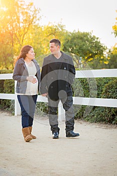 Hispanic Pregnant Young Couple Walking Outdoors