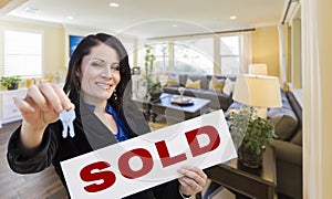 Hispanic Realtor with Keys and Sold Sign in Living Room