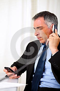 Hispanic senior business man calling on telephone