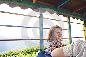 Hispanic senior woman smiles sitting in a chiva, a traditional Colombian vehicle photo