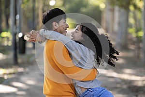 Hispanic smiling couple hugging and loving in park