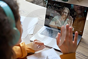 Hispanic teen girl distance learning with online teacher on laptop screen. photo