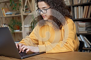 Hispanic teen girl school student using laptop elearning online.