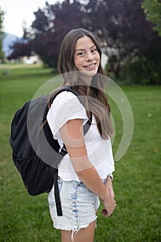 Hispanic Teenage Girl Portrait. A beautiful Latina girl smiling before going to school wearing a backpack outdoors