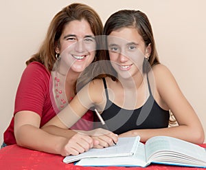 Hispanic teenage girl studying with her mother