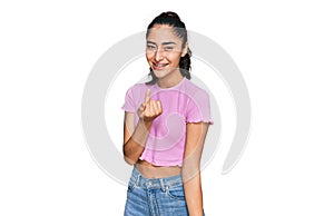 Hispanic teenager girl with dental braces wearing casual clothes beckoning come here gesture with hand inviting welcoming happy