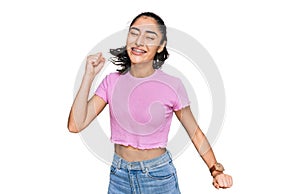 Hispanic teenager girl with dental braces wearing casual clothes dancing happy and cheerful, smiling moving casual and confident