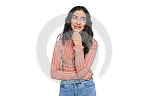 Hispanic teenager girl with dental braces wearing casual clothes with hand on chin thinking about question, pensive expression