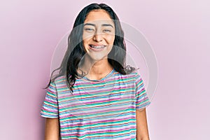 Hispanic teenager girl with dental braces wearing casual clothes with a happy and cool smile on face