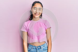 Hispanic teenager girl with dental braces wearing casual clothes with a happy and cool smile on face