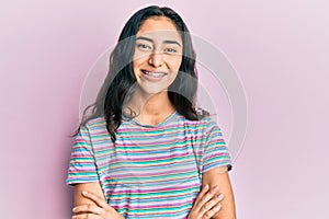 Hispanic teenager girl with dental braces wearing casual clothes happy face smiling with crossed arms looking at the camera