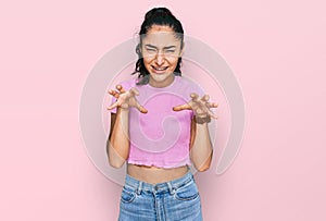 Hispanic teenager girl with dental braces wearing casual clothes smiling funny doing claw gesture as cat, aggressive and sexy