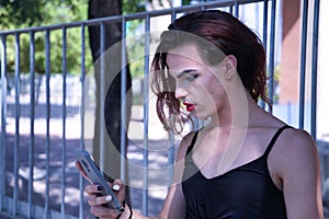 Hispanic and transgender young adult girl consulting social networks on her cell phone. Concept of transsexuality, inclusion and