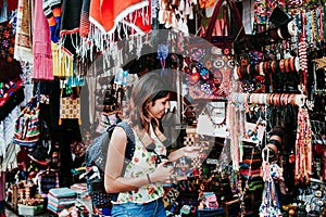 Hispanic woman backpacker buying souvenirs  in a traditional mexican Market in Mexico, Vacations