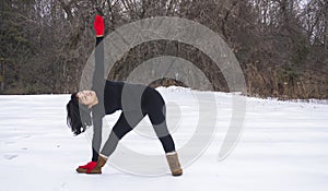 Hispanic woman doing yoga positions outside in winter