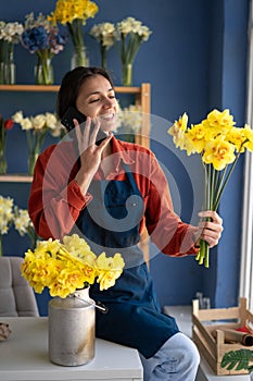 Hispanic woman florist working from home, taking order from client to arrange flower bouquet, delivery.