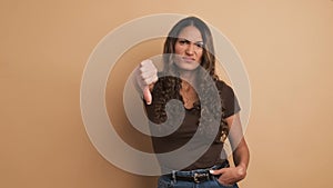 Hispanic woman gesturing disagreement with thumb down