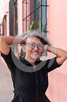 Hispanic woman in glasses posing in the city