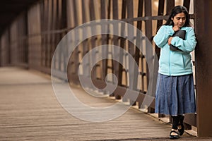 Hispanic Woman Holding Bible On a Bridge