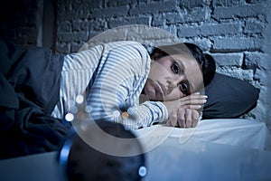 Hispanic woman at home bedroom lying in bed late at night trying to sleep suffering insomnia