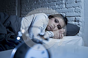 Hispanic woman at home bedroom lying in bed late at night trying to sleep suffering insomnia