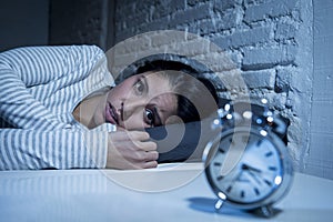 Hispanic woman at home bedroom lying in bed late at night trying to sleep suffering insomnia