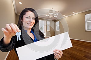 Hispanic Woman With House Keys and Blank Sign In Empty Room of House