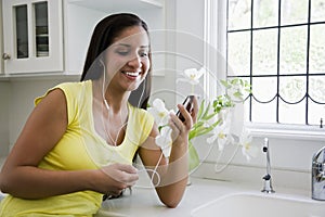 Hispanic woman listening to music on mp3 player