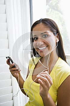 Hispanic woman listening to music on mp3 player