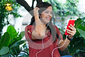 Hispanic woman in the park with video call