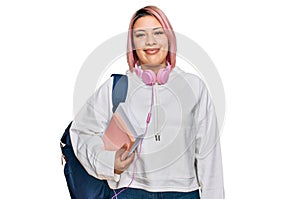 Hispanic woman with pink hair wearing student backpack and headphones with a happy and cool smile on face