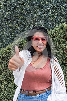 Hispanic woman in pink sunglasses in outdoor