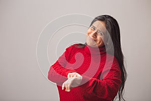 Hispanic Woman Points at her Wrist Watch and Smiles