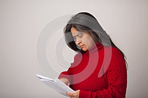 Hispanic Woman Points To Spot On Notebook Page