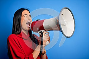 Hispanic woman shouting angry on protest through megaphone