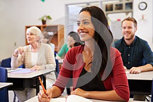 Hispanic woman studying at adult education class looking up