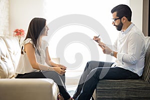 Hispanic woman talking to her therapist at therapy session photo