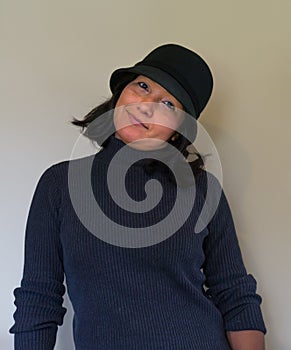 Hispanic woman tilting her head wearing a black wool cloche hat