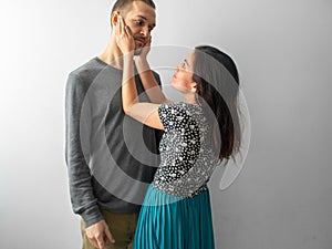 Hispanic Woman Tries to Calm Caucasian Man by Holding his Face