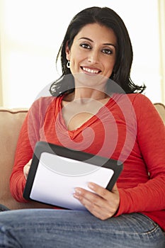 Hispanic Woman Using tablet computer At Home