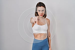 Hispanic woman wearing sportswear over isolated background pointing displeased and frustrated to the camera, angry and furious