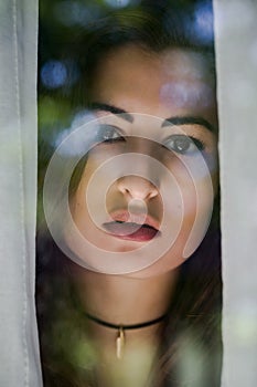 Hispanic women looking into the camera through a window