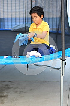 Hispanic 6-year-old boy jumping on a brincolin as a physical activity for a healthy life he exercises and has fun alone at home photo