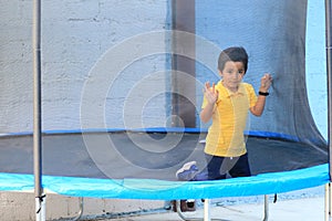 Hispanic 6-year-old boy jumping on a brincolin as a physical activity for a healthy life he exercises and has fun alone at home photo