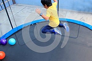 Hispanic 6-year-old boy jumping on a brincolin as a physical activity for a healthy life he exercises and has fun alone at home photo