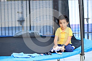 Hispanic 6-year-old boy jumping on a brincolin as a physical activity for a healthy life he exercises and has fun alone at home photo