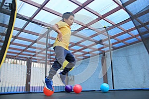 Hispanic 6-year-old boy jumping on a brincolin as a physical activity for a healthy life he exercises and has fun alone at home photo