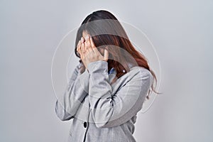 Hispanic young business woman wearing glasses with sad expression covering face with hands while crying