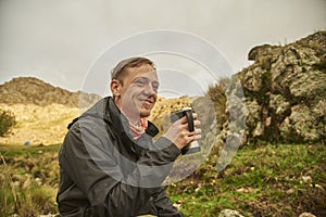 Hispanic young man, backpacker traveler, enjoying a cup of coffee for breakfast