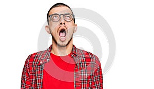 Hispanic young man wearing casual clothes angry and mad screaming frustrated and furious, shouting with anger